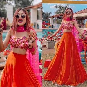 Bright pink and orange Indian wedding guest outfit. Lehenga choli, about medium